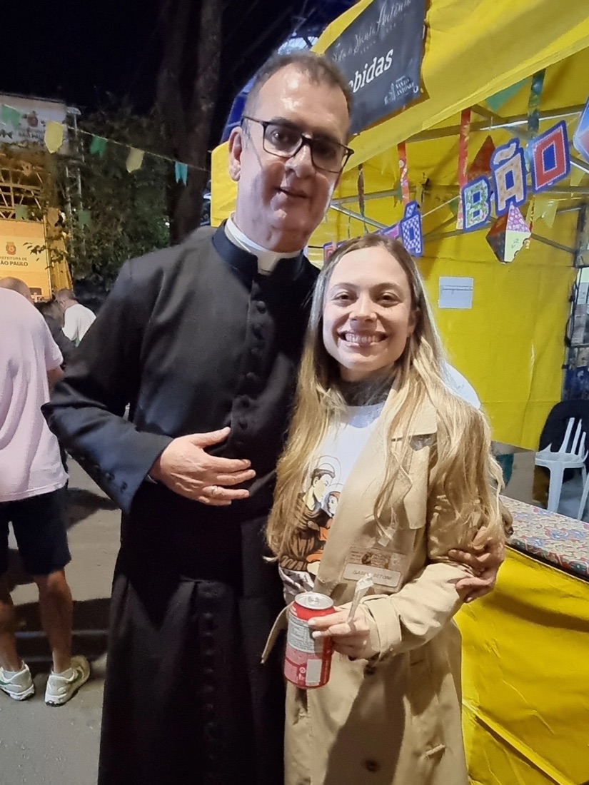 Padre com moradores do bairro na festa